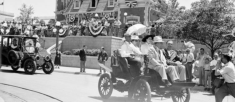 people riding in old cars