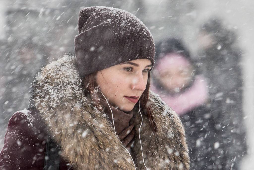A woman walking during a snowfall.