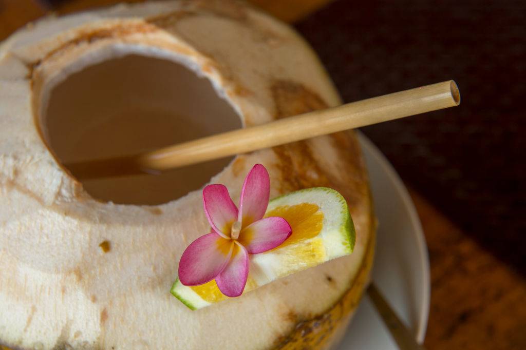 A cold coconut drink with a bamboo straw on Bali, Indonesia.