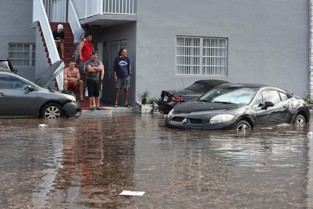 People look out at the flooded parking lot in front of their apartment building on December 23, 2019 in Hollywood, Florida. The area received up to 12 inches of rain