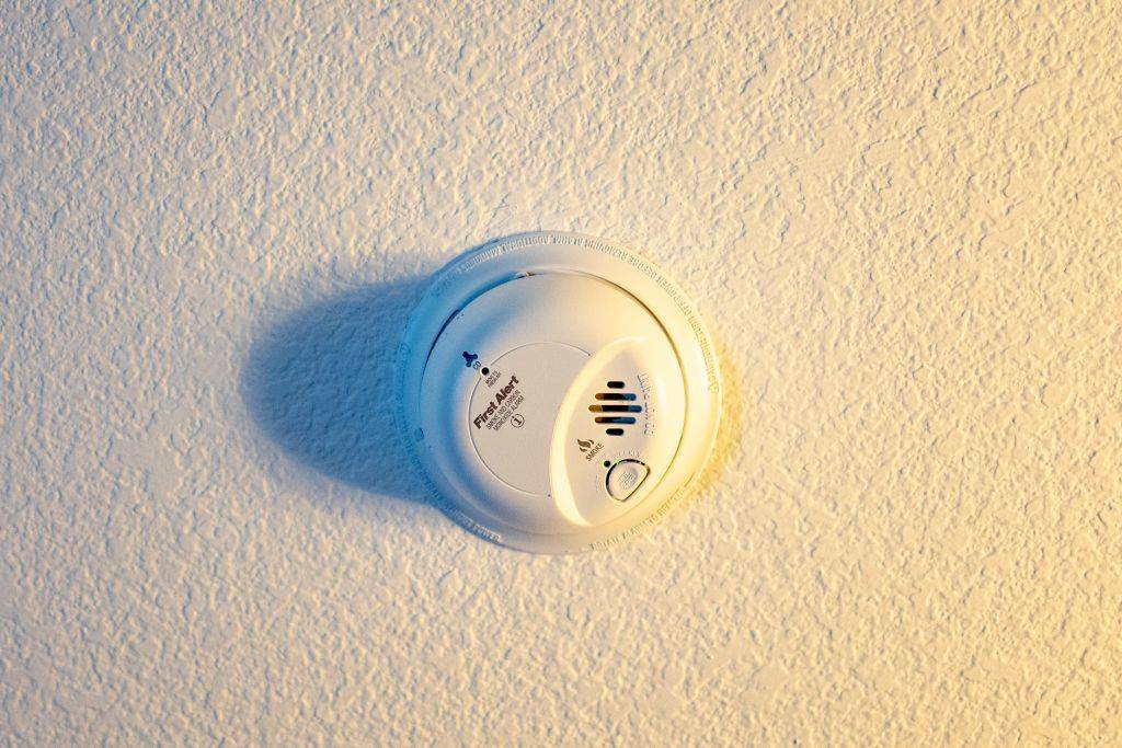 Low-angle view of First Alert smoke detector and carbon monoxide detector installed on a ceiling, in dramatic light, San Ramon, California,