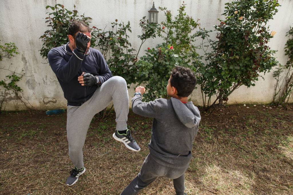 A father fighting against his teenage son, as they practice Karate in the backyard at home, in Ariana governorate, Northern Tunisia, as they try to chase away the vacuity,