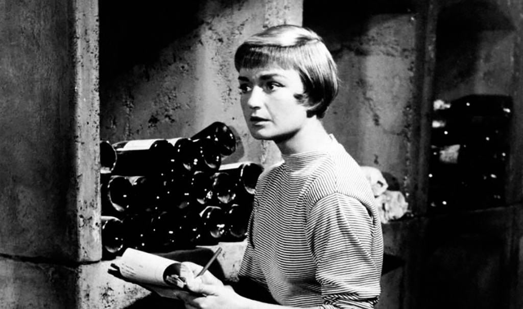 French actress Brigitte Auber sitting in a cellar with a notebook in her hands in the film To Catch a Thief.