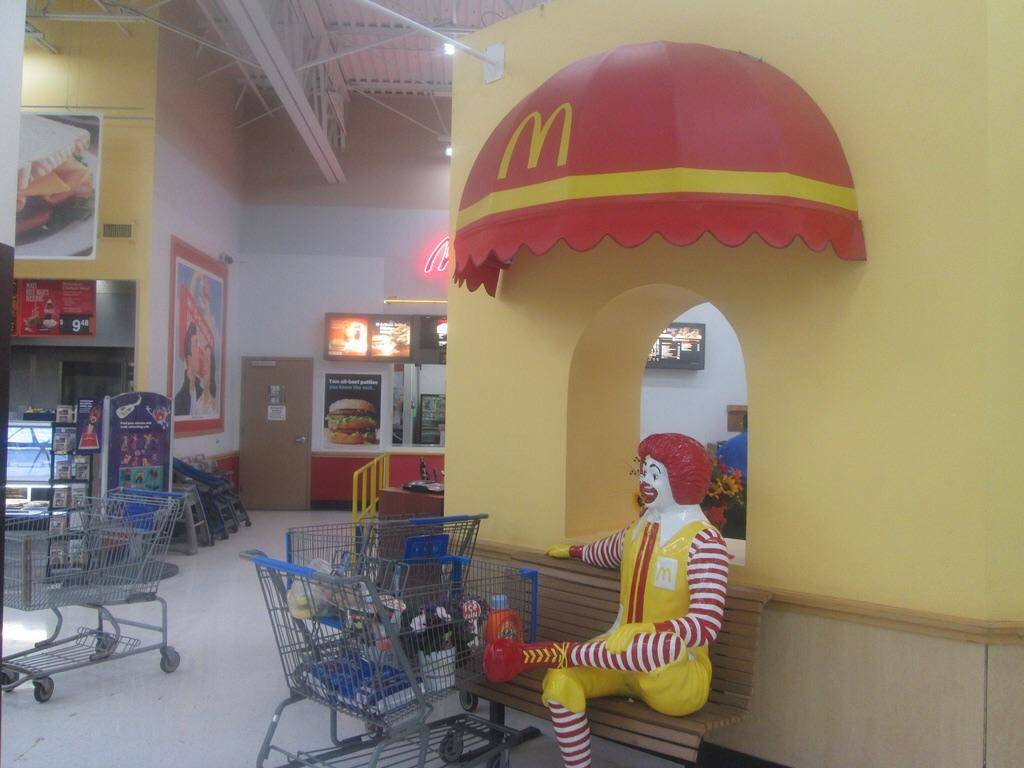 ronald mcdonald on bench in Mcdonald's in a Walmart