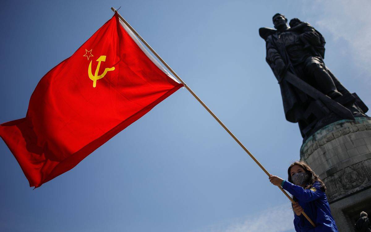 A girl holds a flag of the Soviet Union at the Soviet War Memorial at Treptower Park in Berlin.