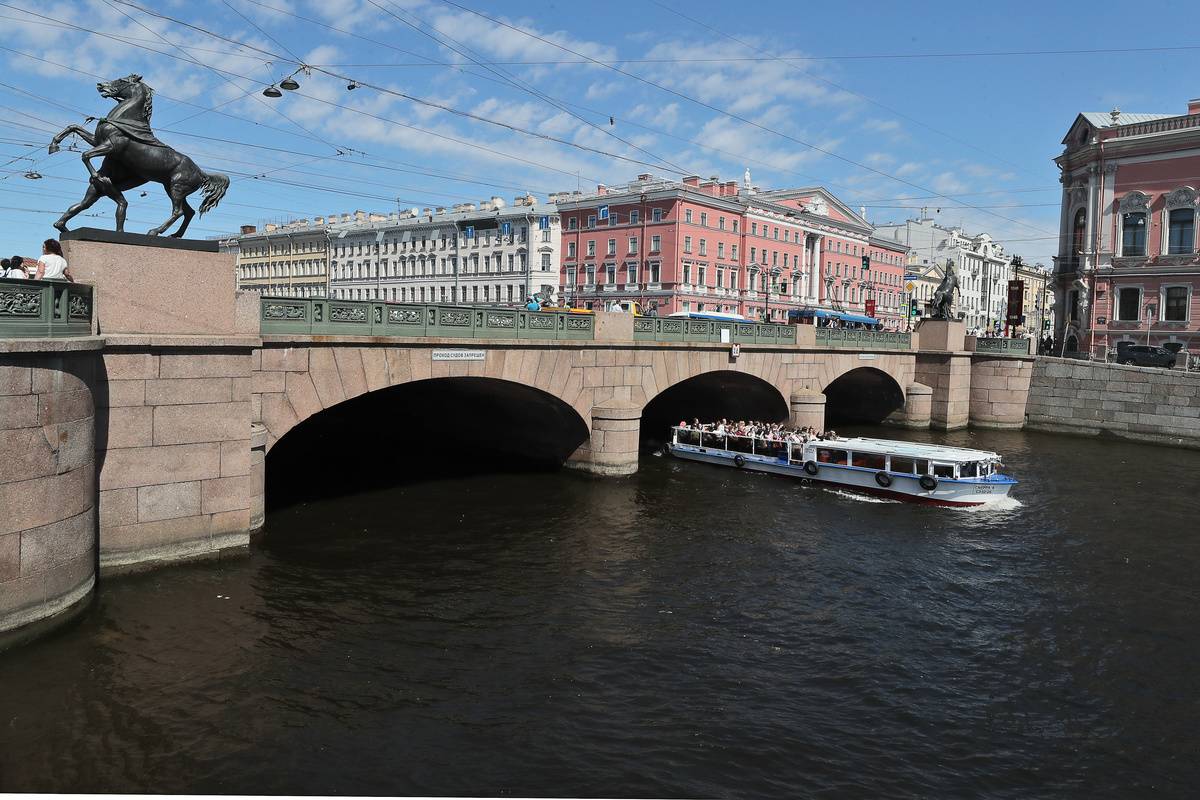 A boat sails under a bridge in St. Petersburg, Russia.