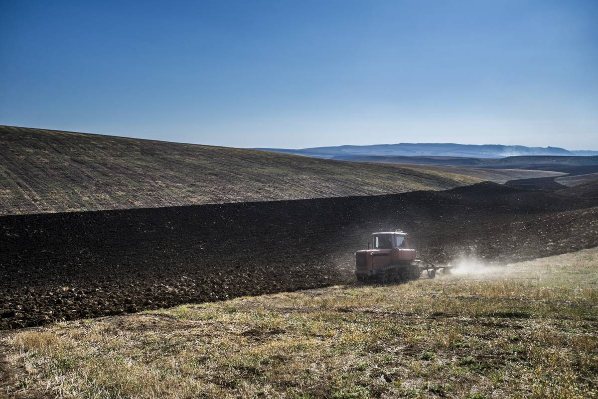 A tractor drives across a Russian farm.