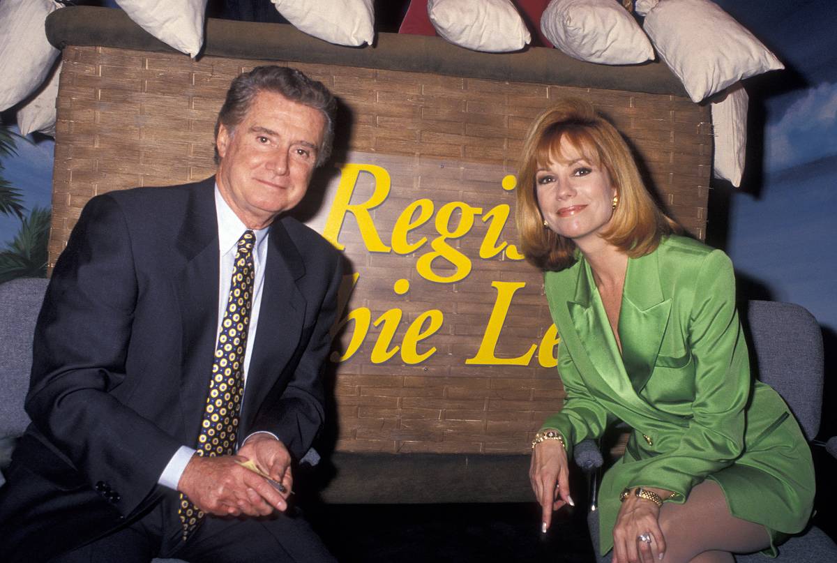 Regis Philbin and Kathie Lee Gifford pose in front of a sign.