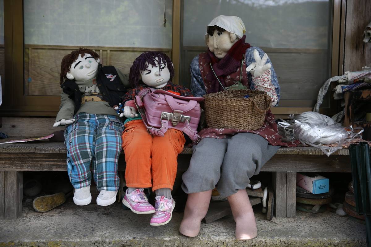 human sized dolls sitting on bench