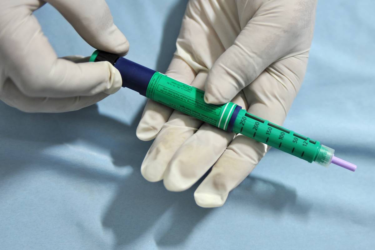 A medical assistant holds an insulin pen administered to diabetes patients