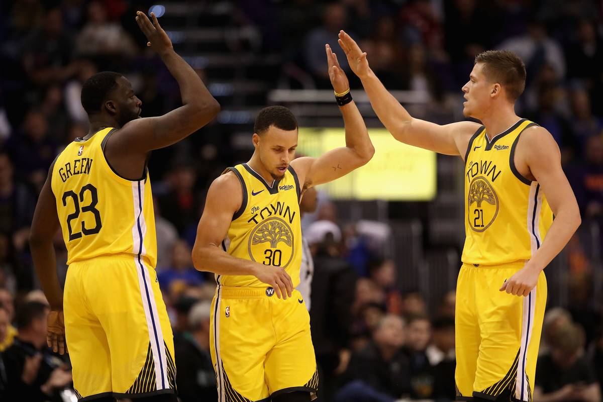 Draymond Green #23, Stephen Curry #30 and Jonas Jerebko #21 of the Golden State Warriors high-five after scoring