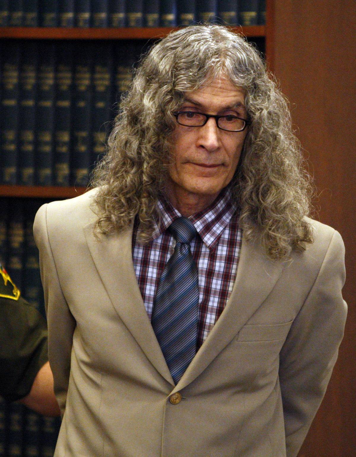 An Orange County Sheriff bailiff leads convicted serial killer Rodney James Alcala into court.
