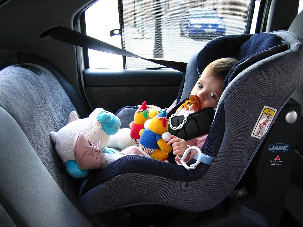 Toddler sitting in car seat.