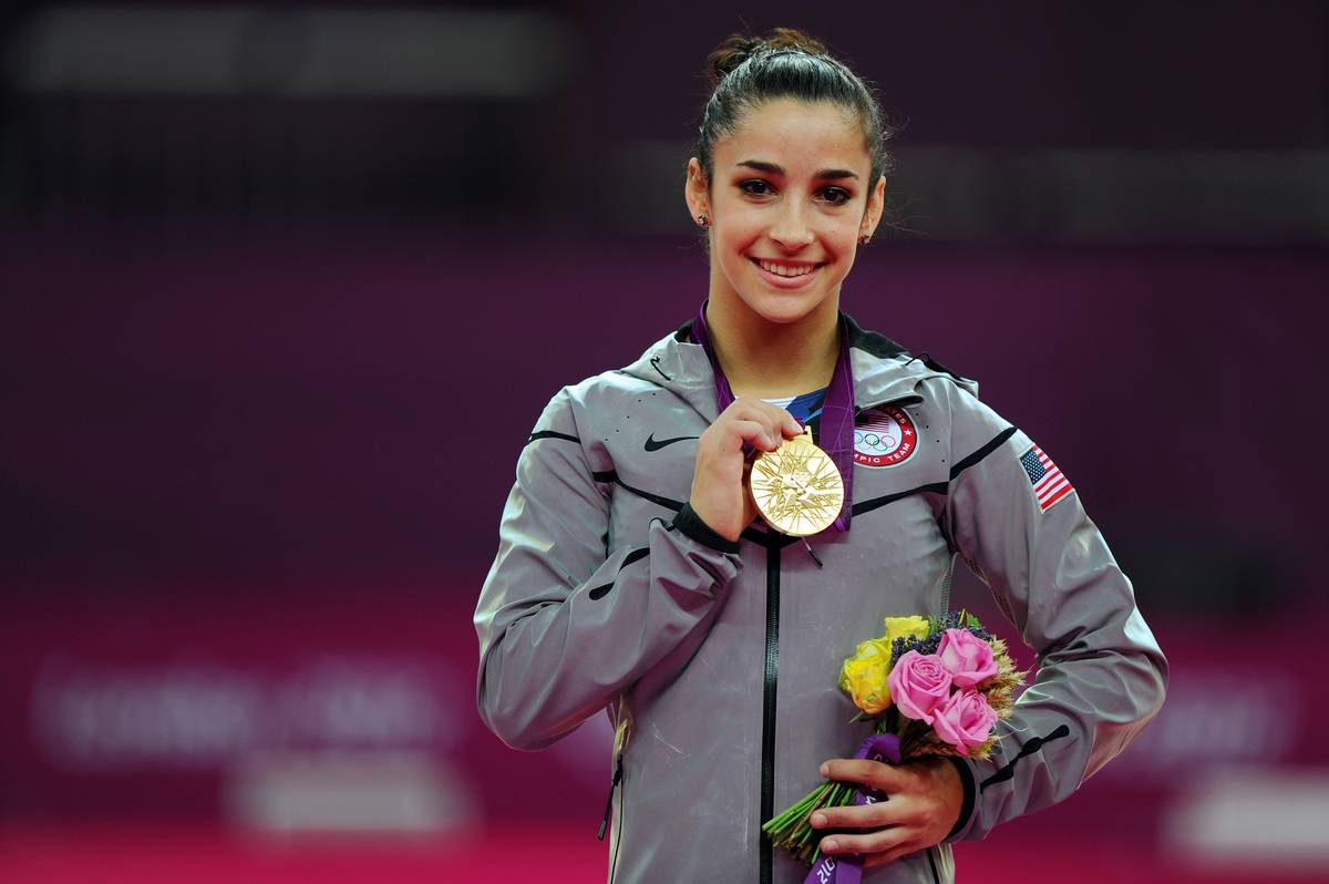 Aly Raisman holds up her gold medal after winning the 2012 Olympic Games.