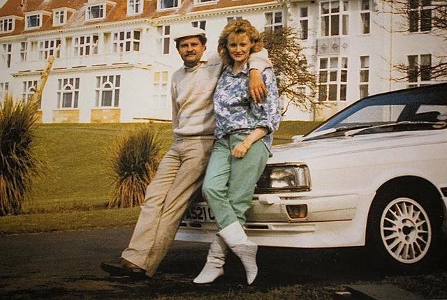 couple leaning on car
