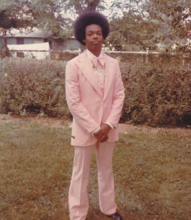man with afro in pink suit