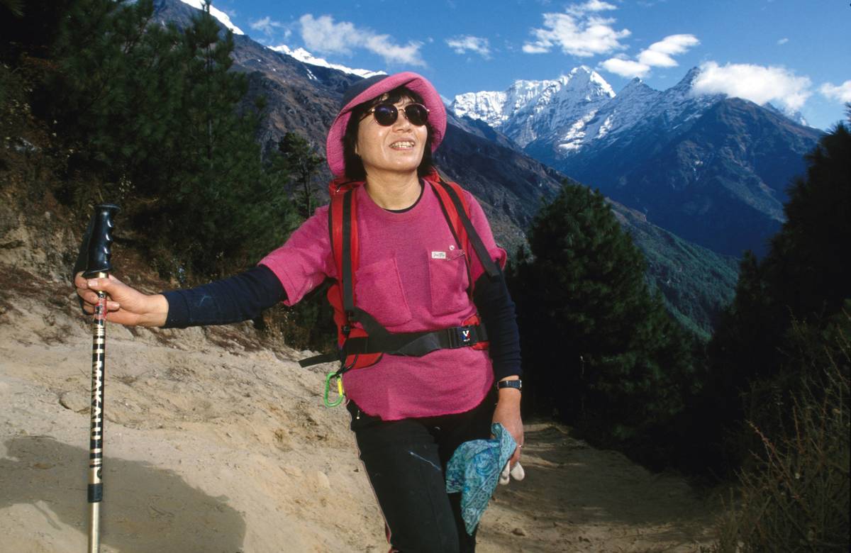 Junko Tabei poses in front of mountains.