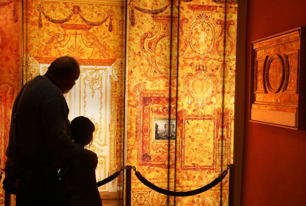 Visitors walk past images of the missing Amber Room