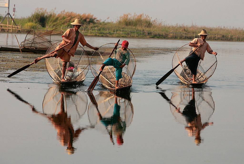 fishermen in myanmar paddling in the water