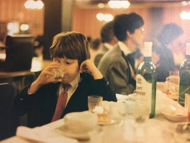 kid sneaking a drink of wine