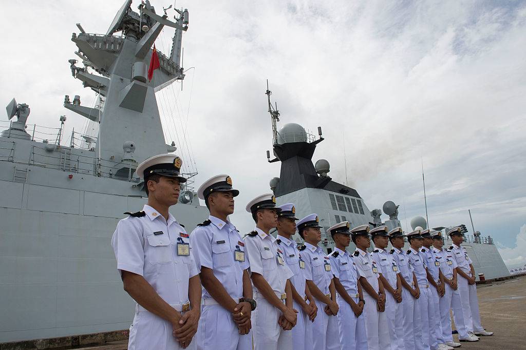 Myanmar navy personnel stand near a ship