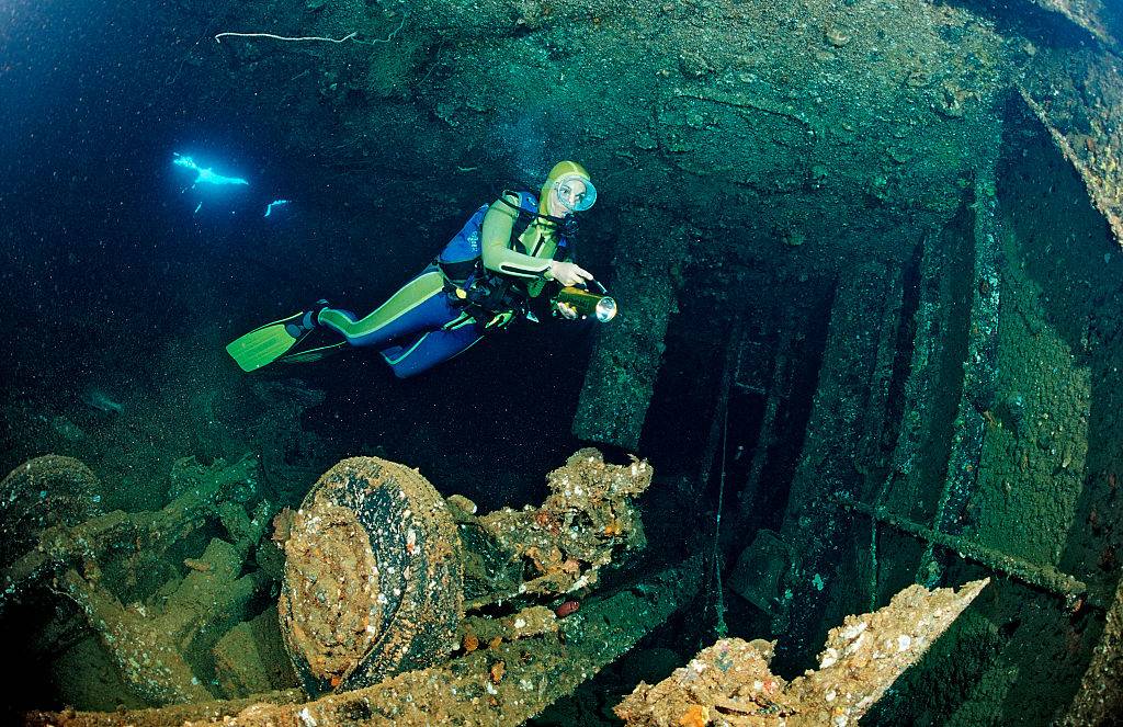 a scuba diver looking at a shipwreck