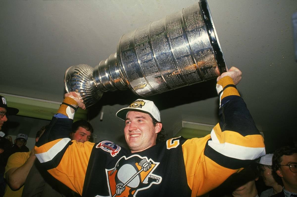 Mario Lemieux hoists the Stanley Cup over his head.