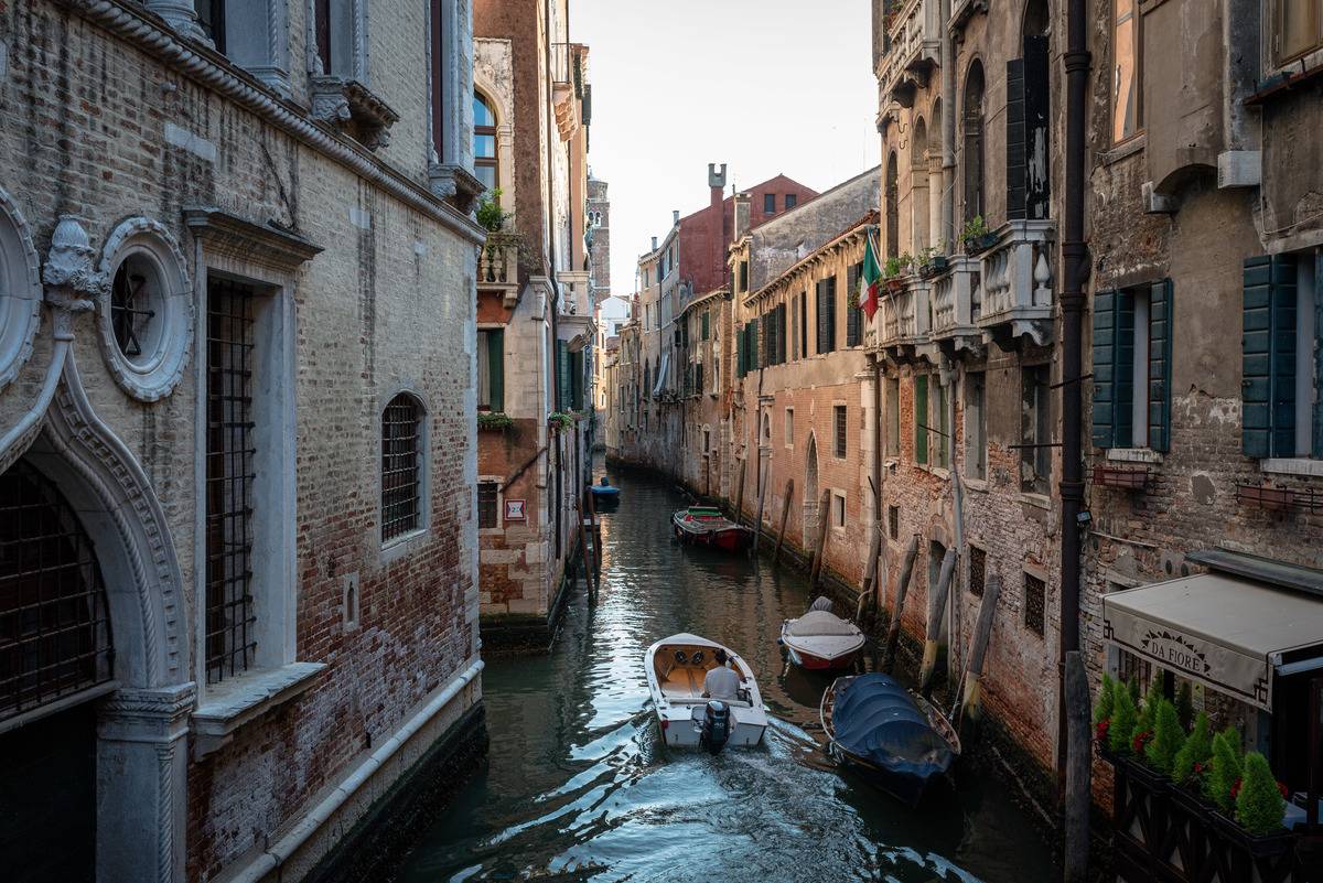 A boat drives through a canal in Venice.