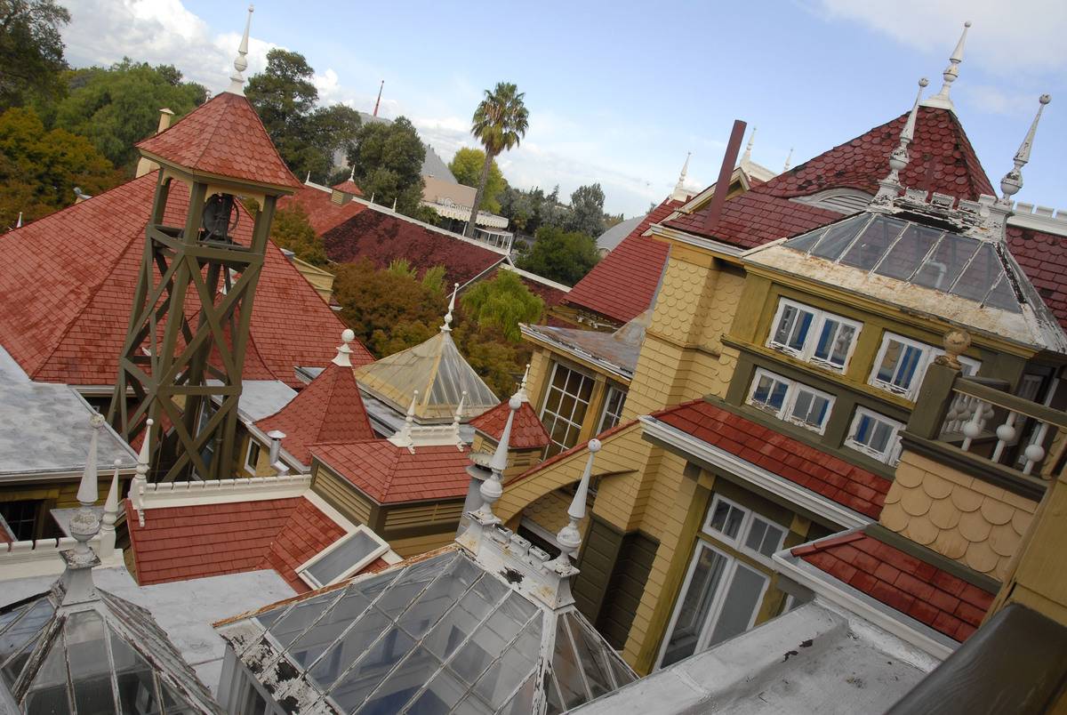 A photo shows the roofs of the Winchester Mystery House.