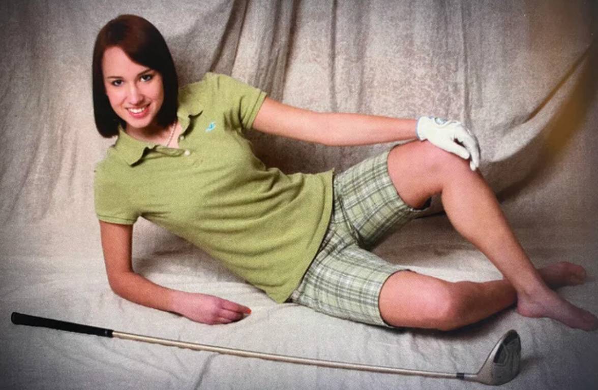 woman dressed in golf attire with no shoes posing with a club