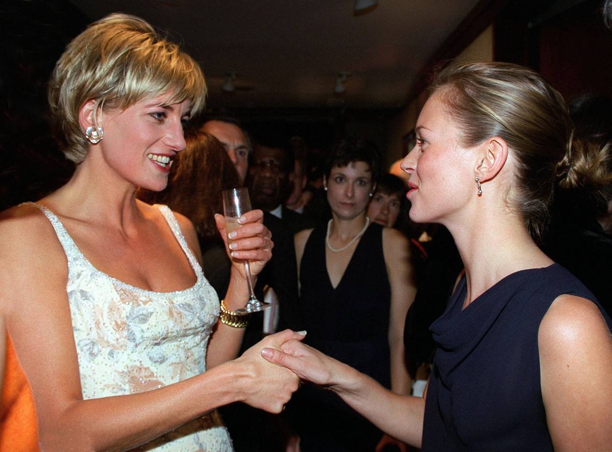 While wearing a low-cut dress by Catherine Walker, Diana shakes hands with supermodel Kate Moss.