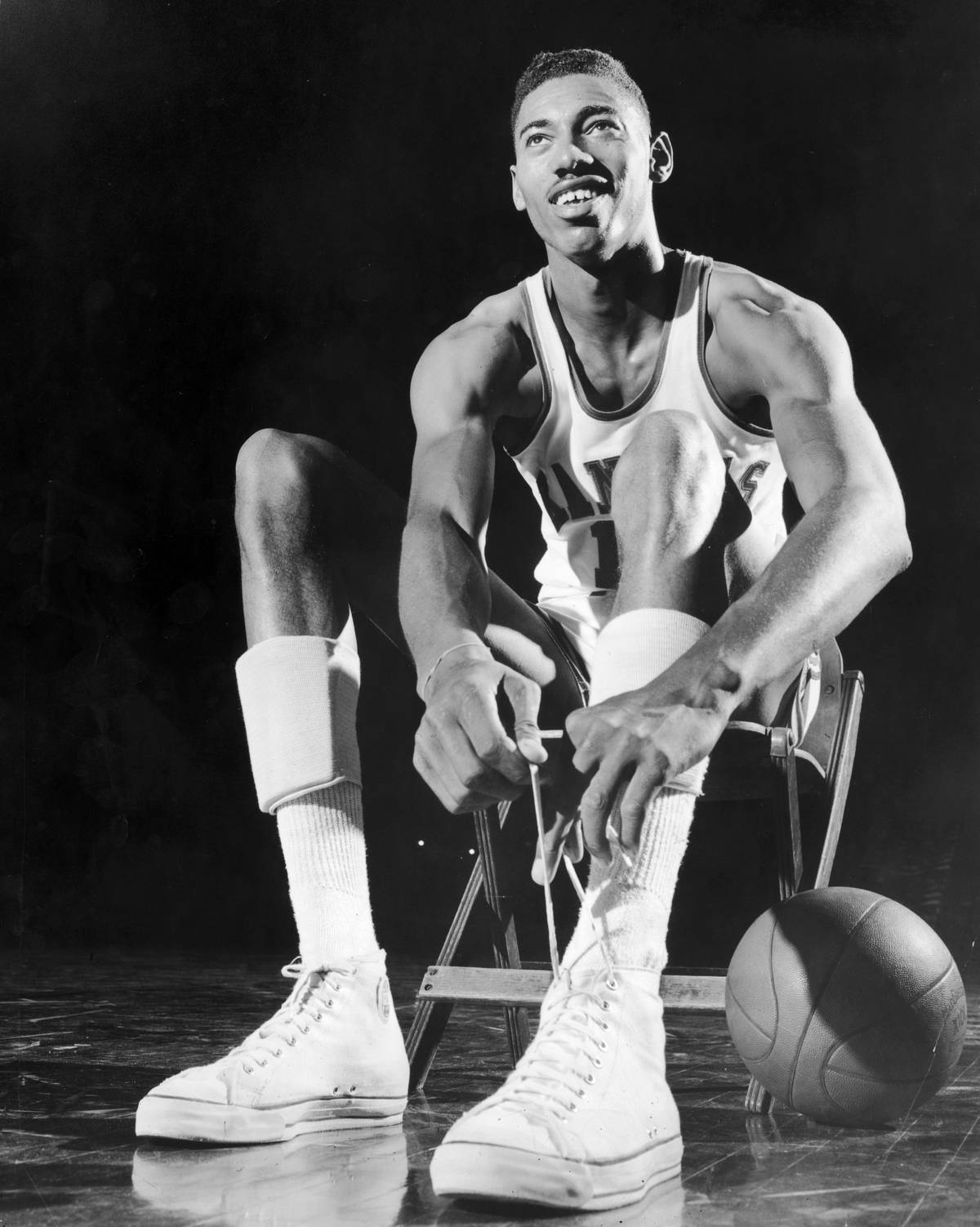 Wilt Chamberlain tying his shoes as a rookie