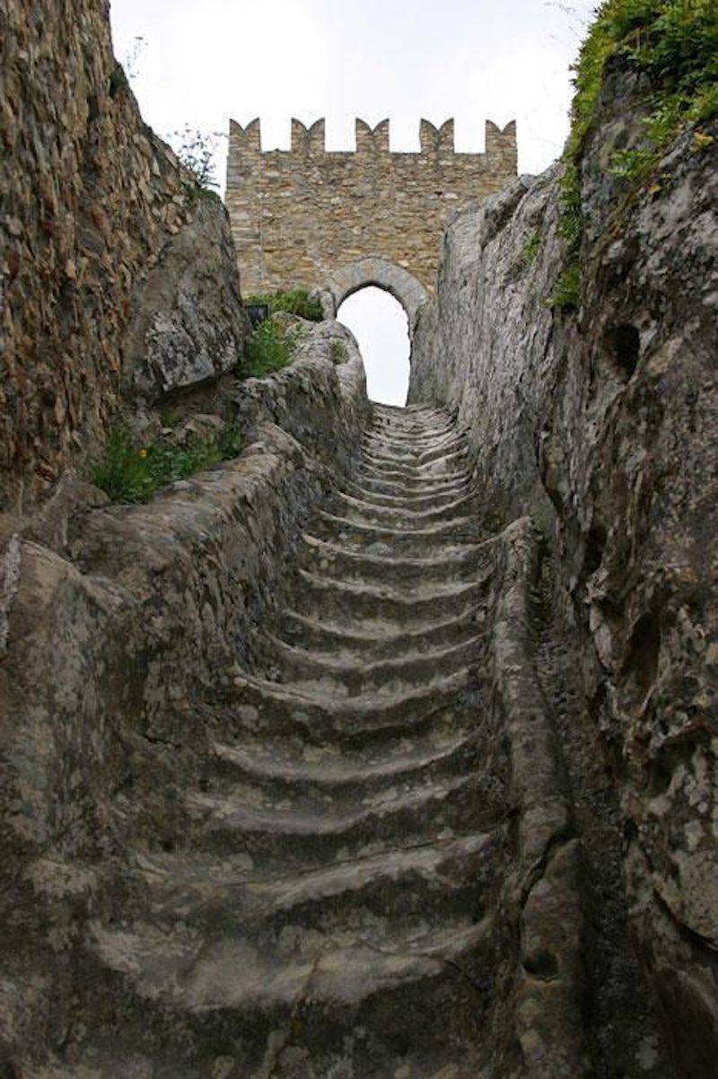 old dented stairs leading to archway