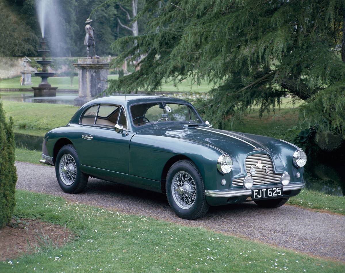 A 1952 Aston Martin DB2 saloon car photographed in a stately garden.