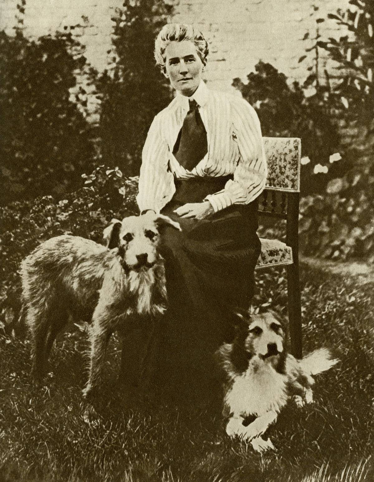 Edith Cavell pets her dogs in this early 1900s photograph.