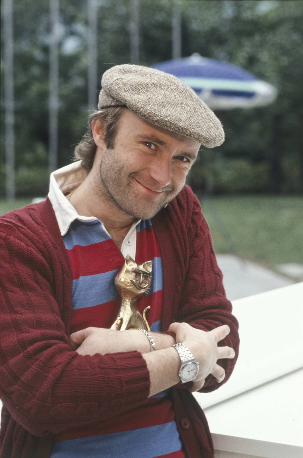 Phil Collins posing with the Telegatto award he won