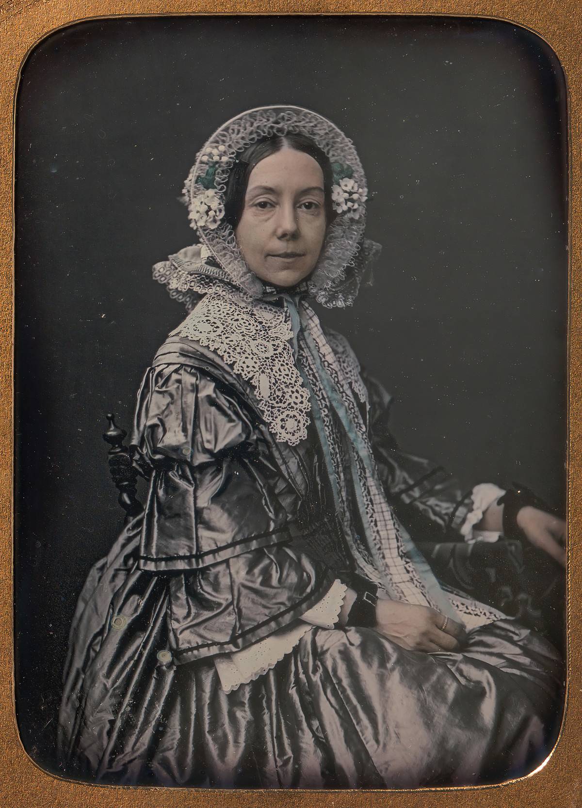 A middle-aged woman is well dressed for an 1854 picture.