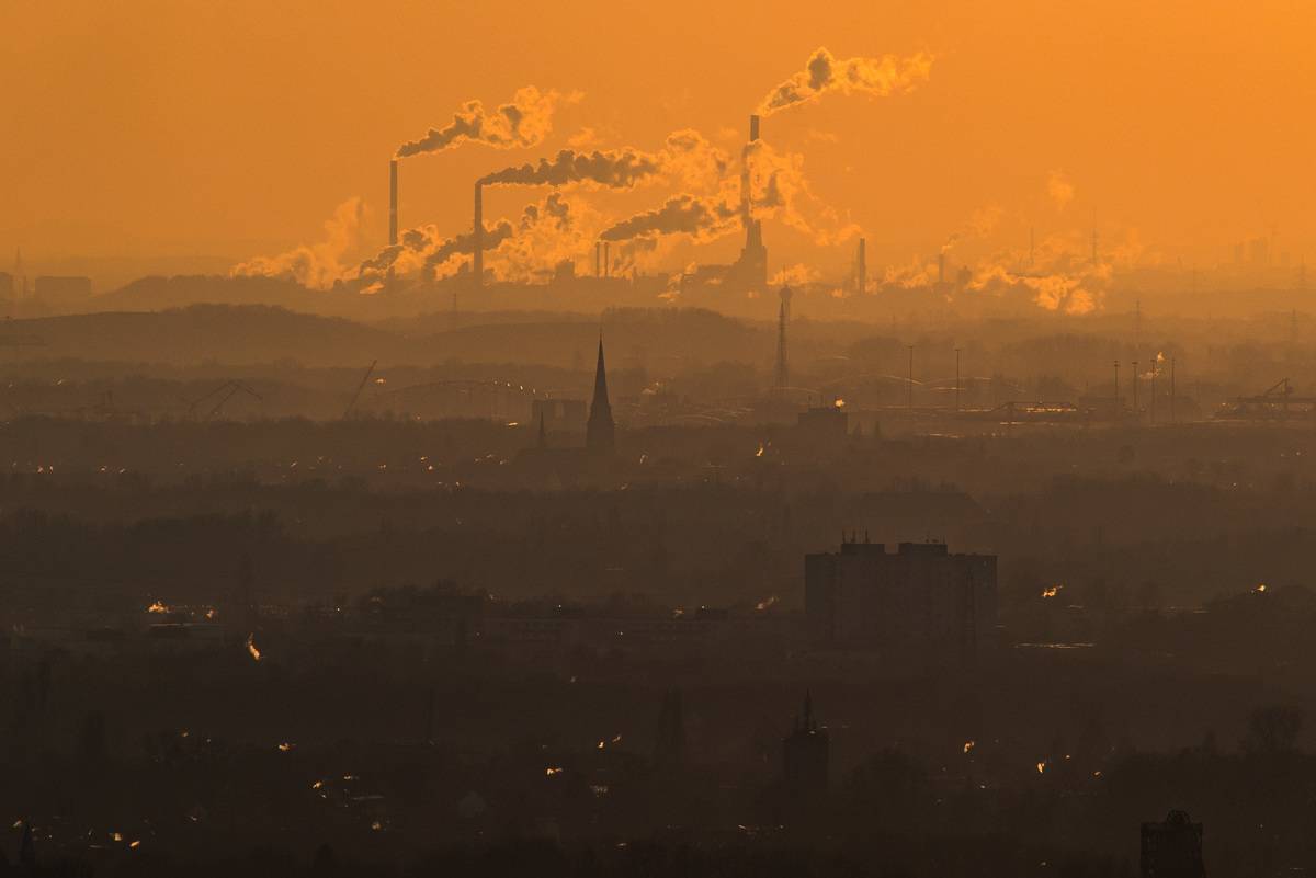 Factory smoke is seen on the horizon during extreme heat.