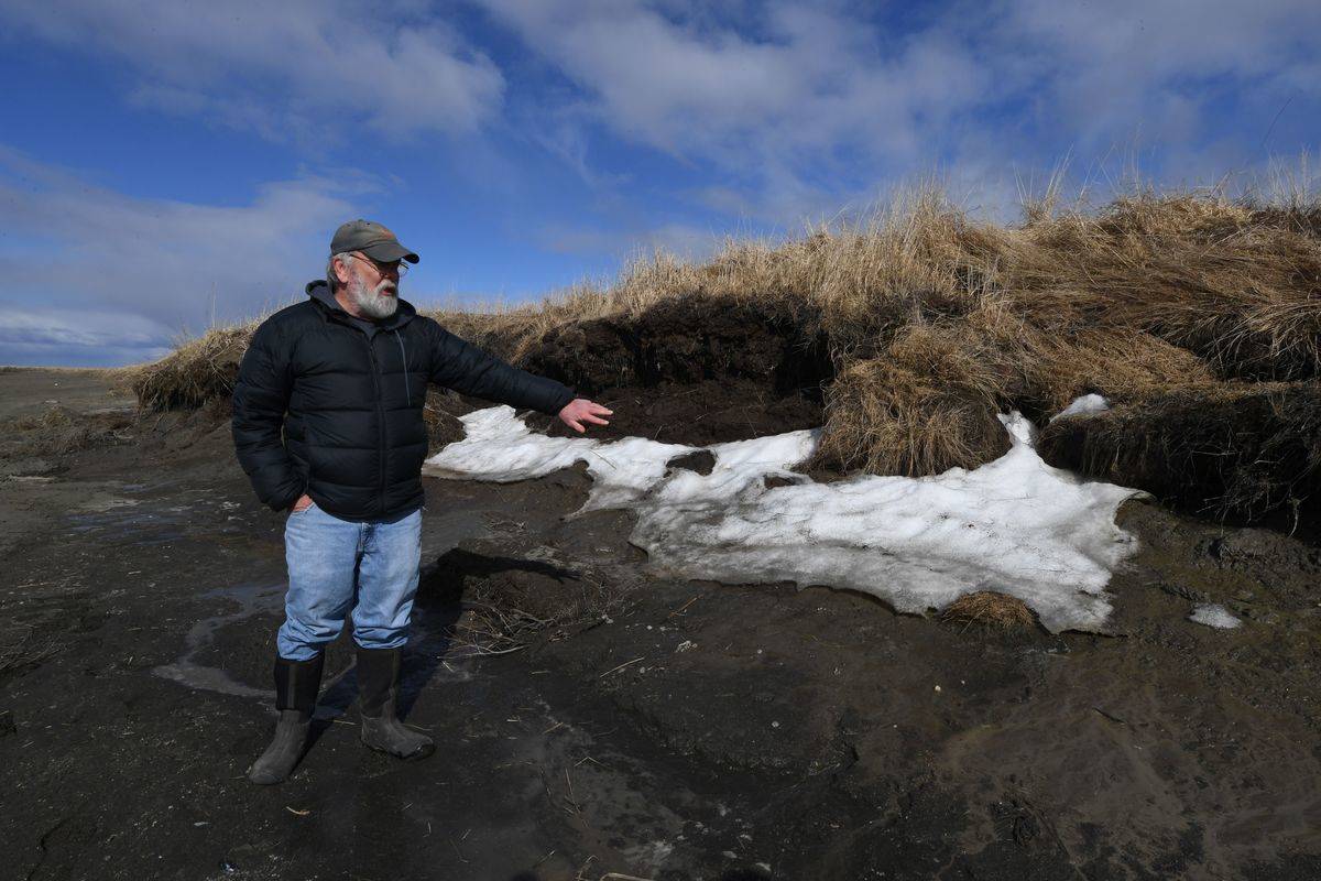 An archaeologist points to melting snow in the Arctic.