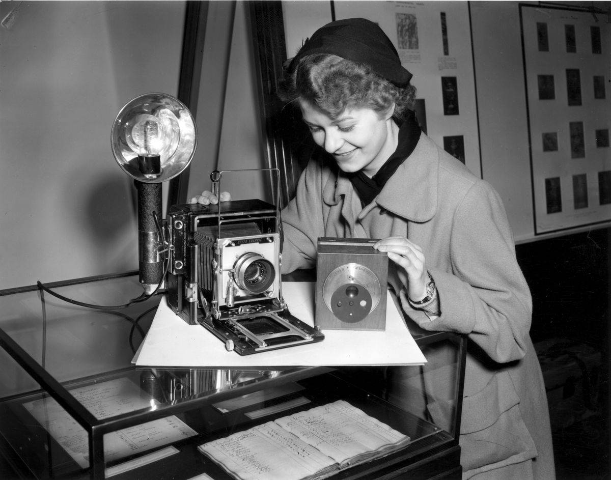 A woman works with a daguerrotype camera.
