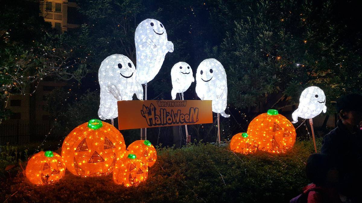 Light-up ghosts and pumpkins surround a halloween sign.