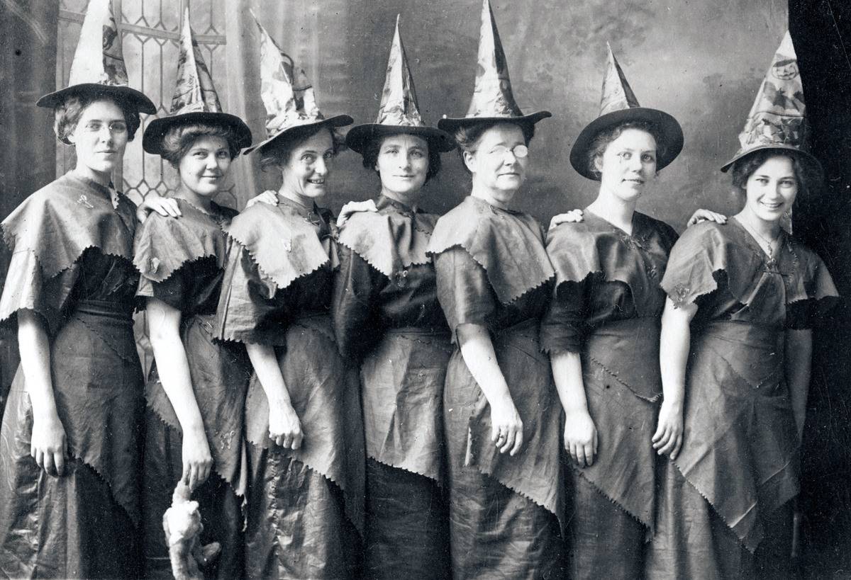 A group of women dressed up as witches in a photo from 1910