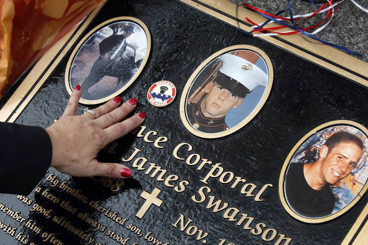 A woman touches a corporal's grave.