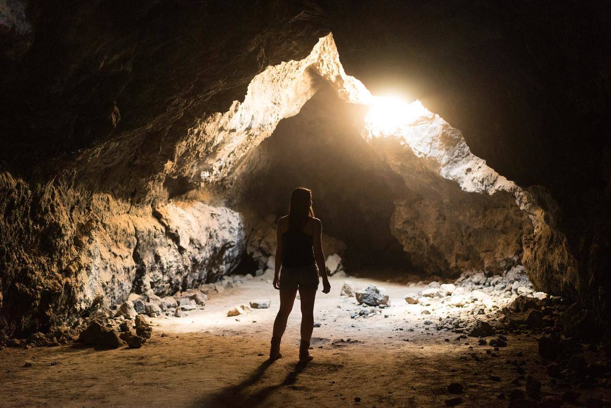 person walking through a cave