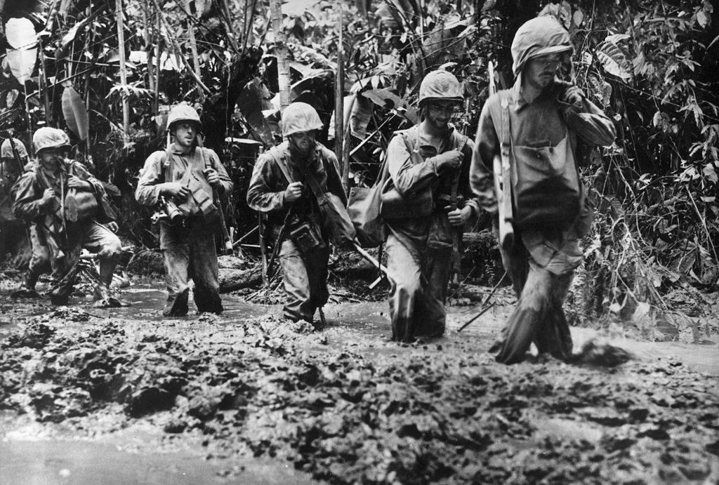 A detachment of US Marines plough through knee-deep mud on their way to confront the Japanese on Bougainville Island in Papua New Guinea