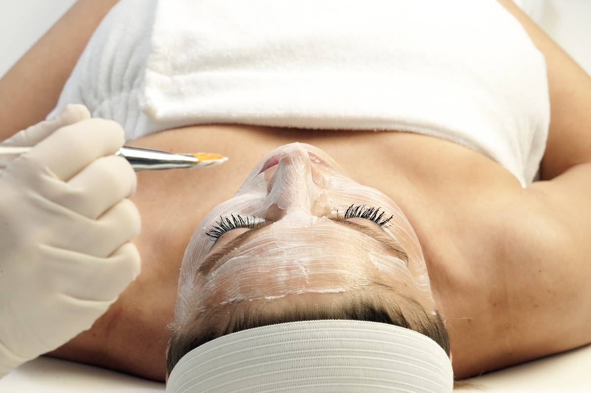 Woman getting a facial treatment at a spa...