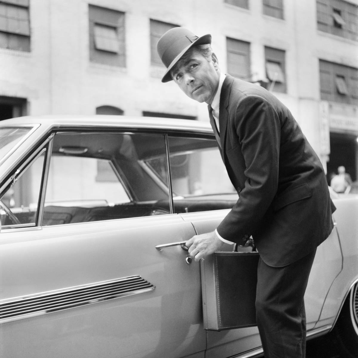 1960s BUSINESSMAN CARRYING...