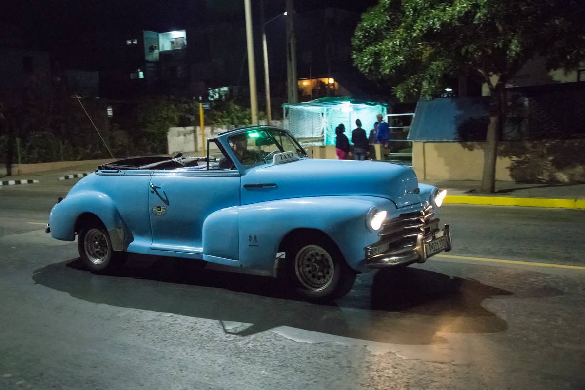 Old vintage American blue car in action at night. The...