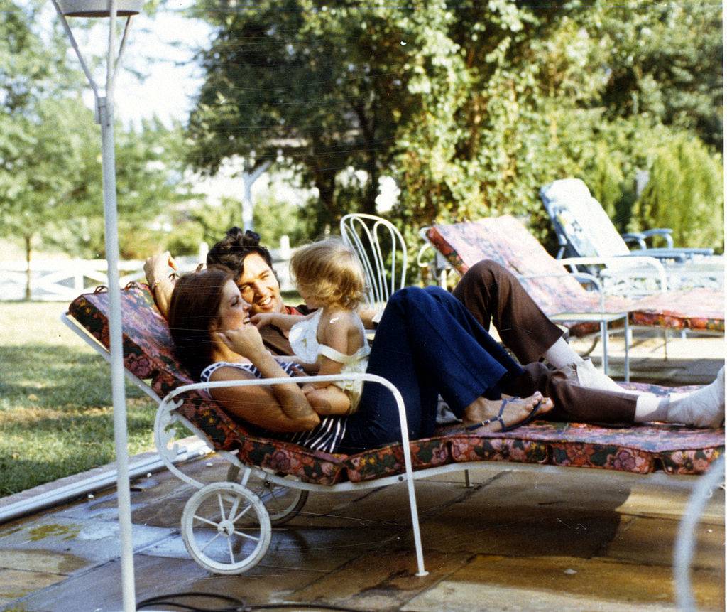 Priscilla Presley, Lisa Marie Presley & Elvis Presley at home on a lounge chair