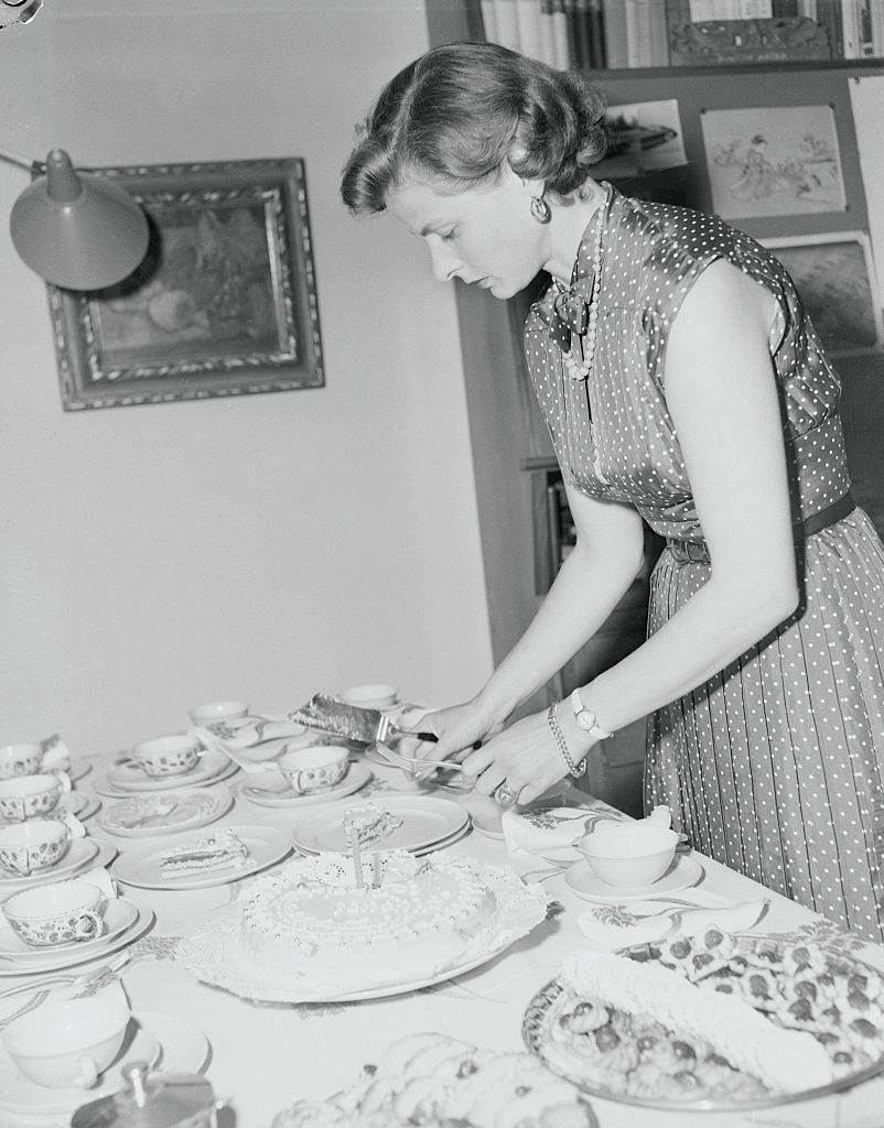 ingrid bergman cutting a cake at home
